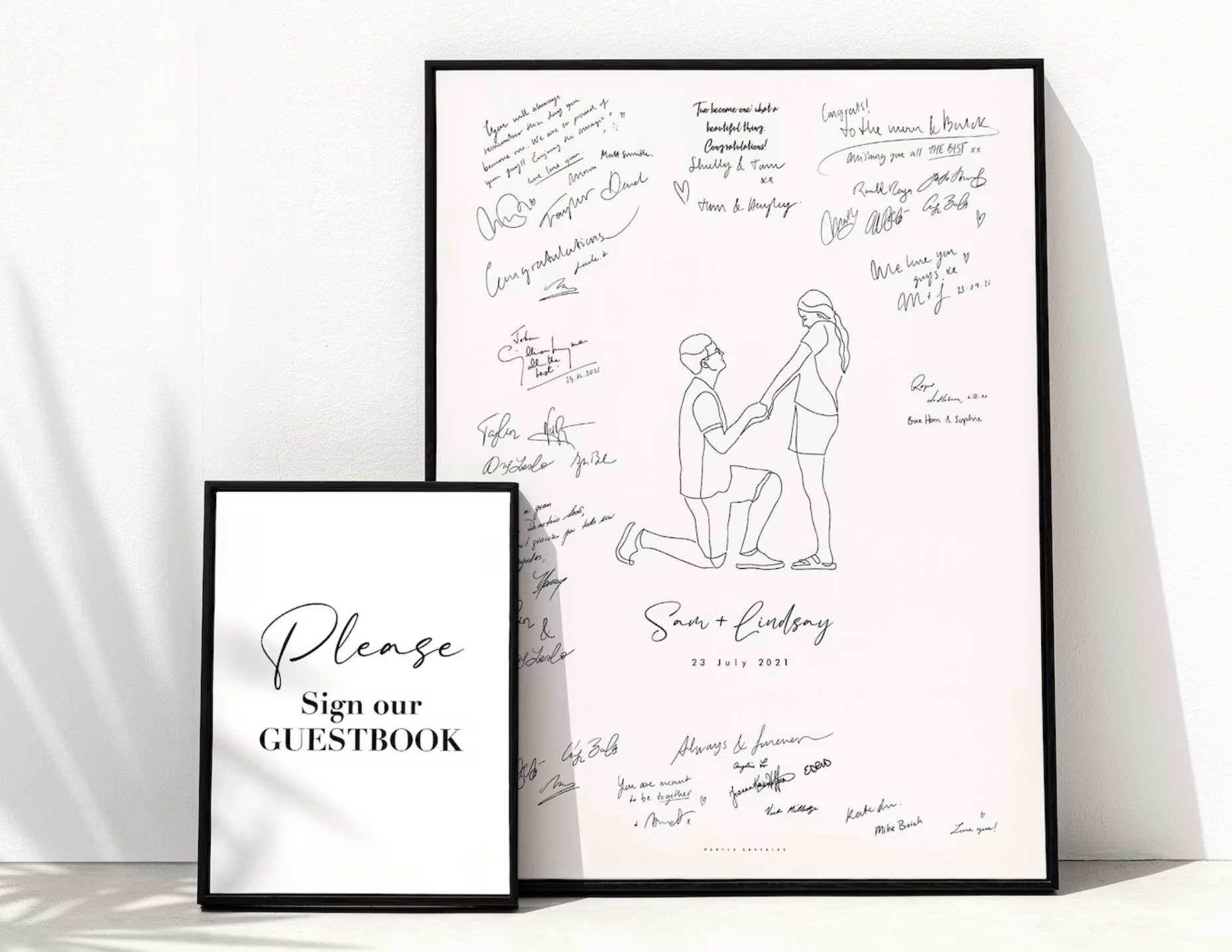 Framed guestbook with signatures and a couple illustration on a white background