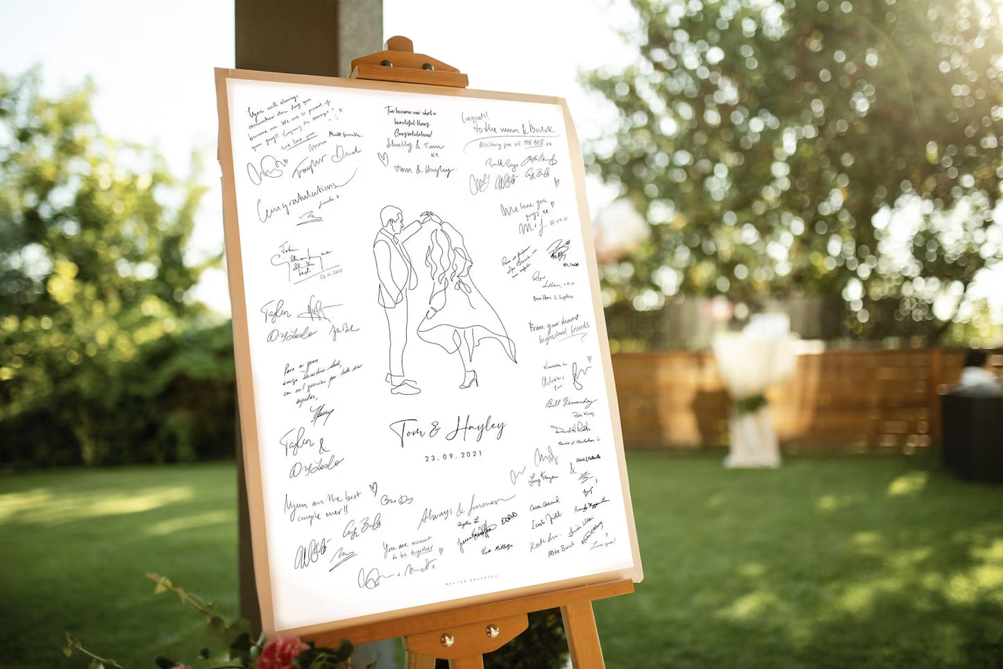 Wedding guestbook with signatures on an easel outdoors